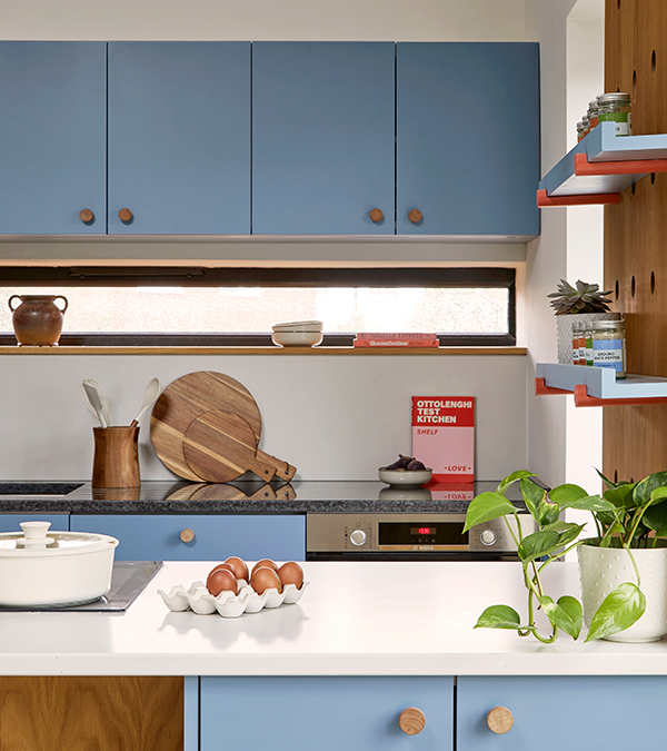 Detail showing the slot window above the sink, the dark granite kitchen worktop, the light Silestone backsplash and Island surface.