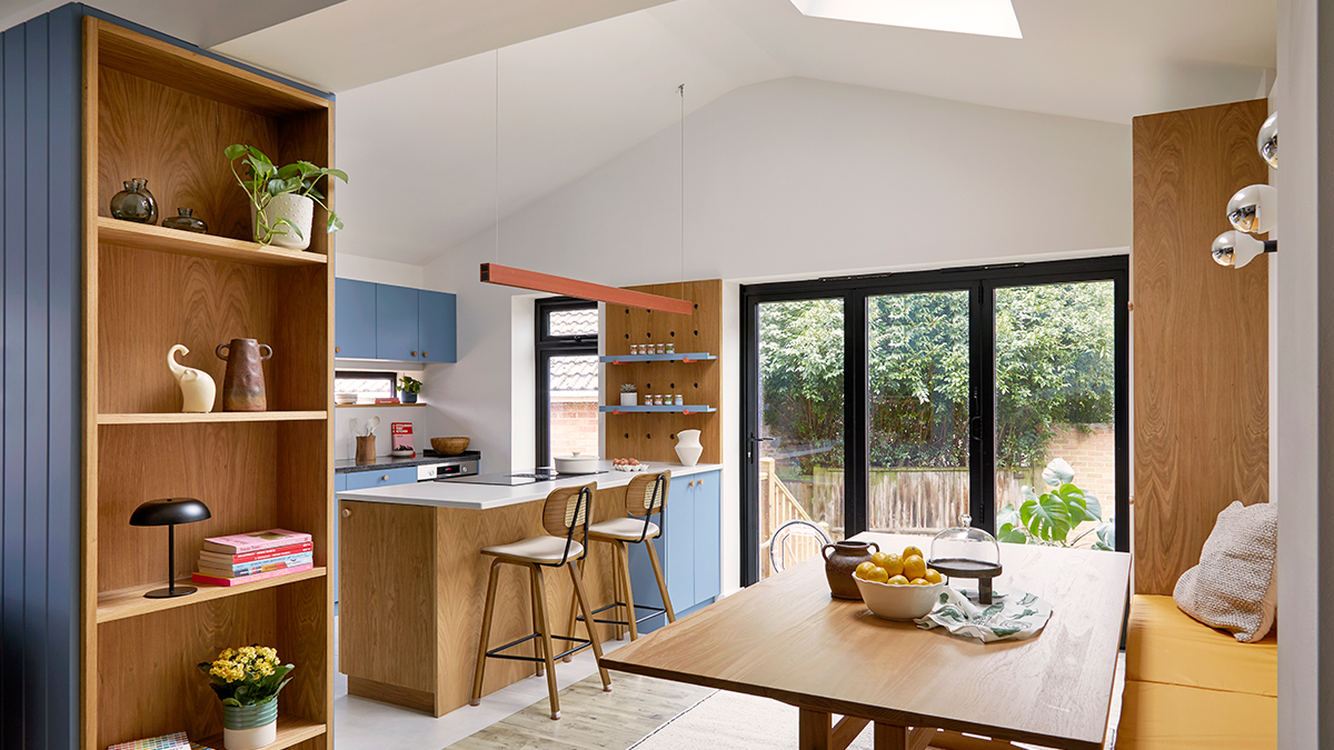 Bright Kitchen/Dining space integrated with Garden, with inclined ceiling, sky window, nice wooden niches and bespoke modern banquette.