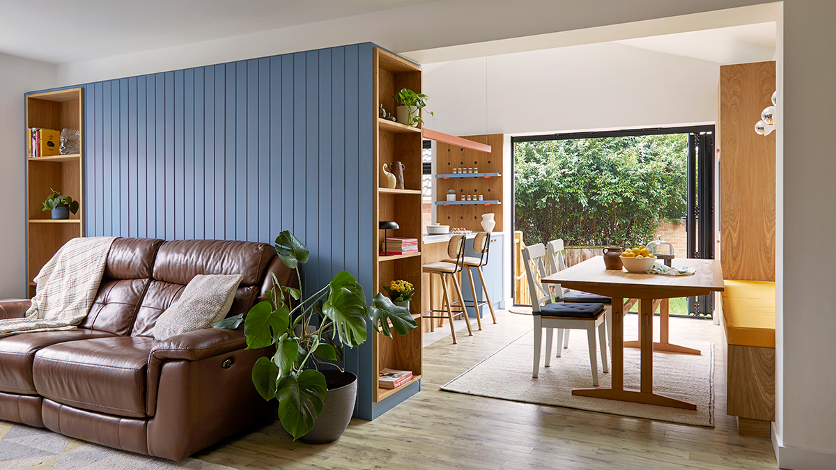 View of the joinery dividing TV Room and Kitchen where a nice blue slated panel act as back of the sofa with side wooden decorative niches to both sides.