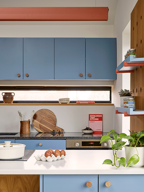 Detail showing the slot window above the sink, the dark granite kitchen worktop, the light Silestone backsplash and Island surface.